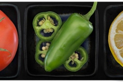 a triptych depicting high resolution close ups of a pristine tomato, a  green jalepeno and a slice of lemon