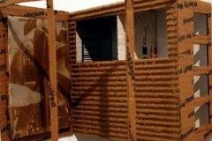 Small cardboard structure mounted on wall.
