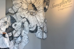Site specific Installation at the Newport Art Museum. An overlapping stream of flowery, muscle tissue like donut forms overlap and rise up a wall.