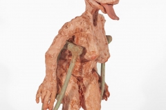 Female figure, orange with tongue out walking on crutches.