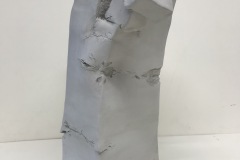 Tall rectangular form with decomposing appearance at top.
