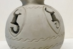 Vase form with impressed pattern, and cutouts on surface and a wide fluted ending.