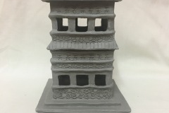 Tall pagoda shaped form with cutouts serving as implied windows.