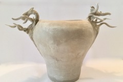 Vase form wider at the top with sculptured tree branches on the sides.