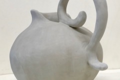 Large pitcher form with high curled handle.