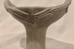 Narrow bottomed, wide fluted topped vase form.