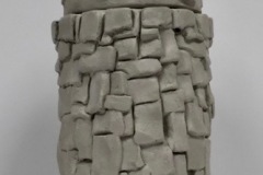 Tall jar form, rounded shape with tile like applique on surface.