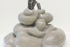 An amorphous, abstract sculptural for in which end openings are filled with nails.