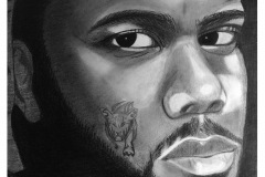 self portrait of a man with strong eyes looking over his shoulder at the viewer. He has a tattoo of a tiger on his cheek .