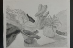 Still life featuring household objects: nike sneaker, houseplant, and baloon animal. Again light tones created by smudging and blending charcoal.