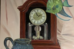 Another fantastical still life where an exotic fish swims in the air around an old timey clock. a handmade mug the same color as the fish sits before the clock.