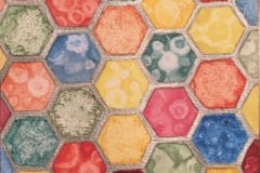 A honeycomb pattern fills the composition. within each hexagon is a different color applied in different techniques, creating a variety of textures.