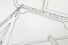 A hanger, pliers, scissors and notebook arranged at angles to eachother and cropped by the page edge.