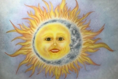 colorful rendering of a shining sun, with a womans face.the sun is embraced by a crescent moon, also with a face.