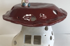 large mushroom shaped house jar, glazed with white at the bottom, red at the top and a small knome at the very top.