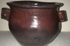 vase form with small side handles glazed red.