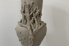 Vase form with a cherry tree in blossom sculpted onto the surface.