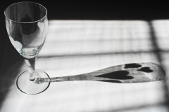 black and white image of the shadow cast by a wine glass with heart decals.