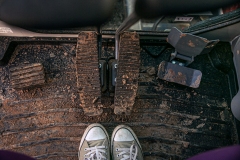 image of feet in converse all stars and a muddy floor mat in a vehicle of some sort.
