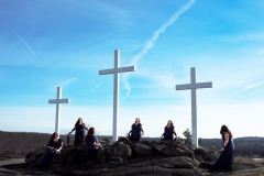 image of three white crosses with many women beneath them.