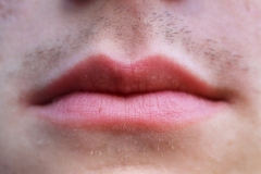 image of a young mans lips, stubble growing in.