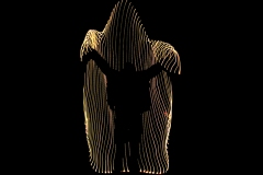 string of lights in darkness form shape of a being larger than human shadow within.