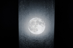 image of full moon through cracked looking window.