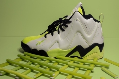 colorful neon sneaker standing atop a grid of neon candy sticks.