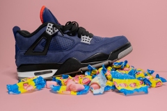 blue sneaker standing atop pile of bubble gum and wrappers.