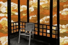 A photograph of a white plastic lawn chair sitting on a platform among painted orange clouds.