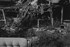 black and white photo of a strange broken down haunted looking house.