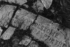 black and white image of words written on brick.