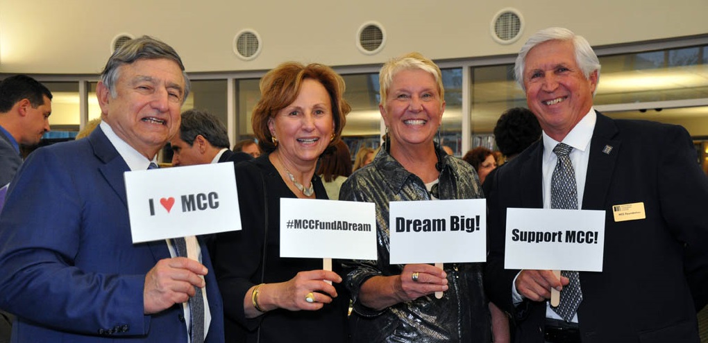 MCC Foundation members holding signs